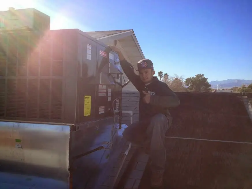 HVAC technician performing Boiler Repair on a rooftop unit in Monett